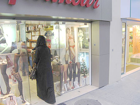 Veiled women entering a lingerie store